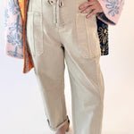 Person wearing beige pants with a colorful jacket on a white background