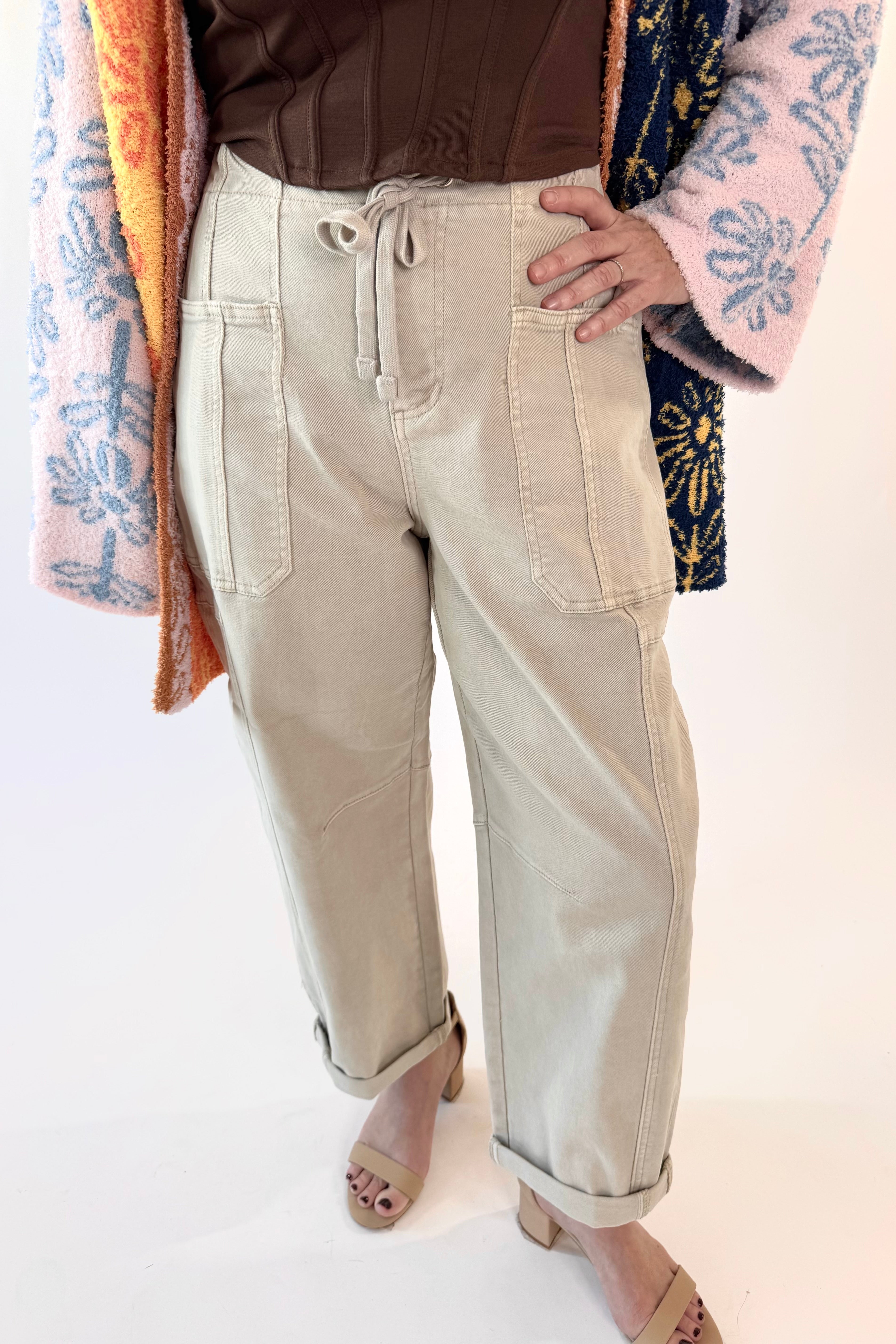 Person wearing beige pants with a colorful jacket on a white background