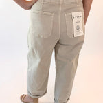 Light-colored pants with a visible brand tag on a plain background
