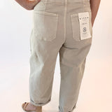 Light-colored pants with a visible brand tag on a plain background