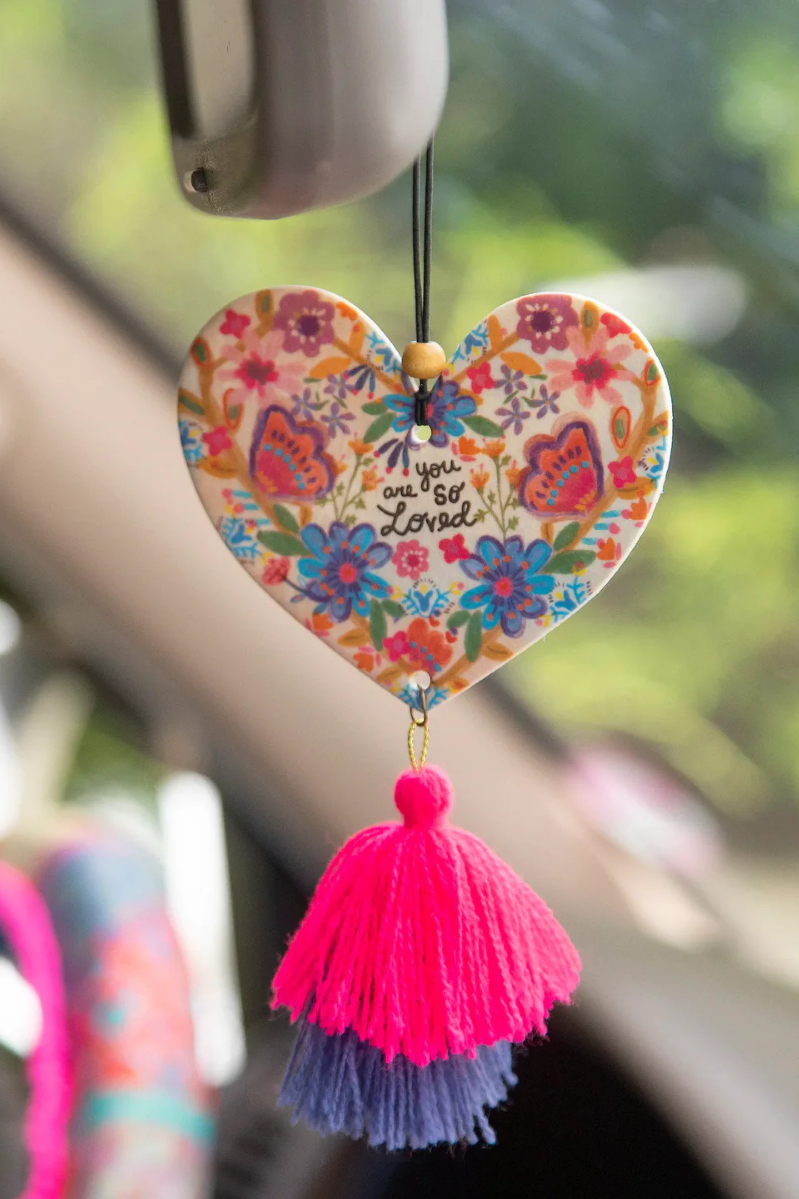 You Are So Loved Air Freshener | Natural Life | Spread the love with our You Are So Loved Air Freshener! Infused with Rose Musk-scented essential oil, this double-sided freshener not only adds a boho vibe with a yarn tassel and wooden bead, but it also brings a lovely scent to your car or personal space. Elastic string makes it easy to hang anywhere.
Scent: Rose Musk-scented essential oil
Pressed paper with essential oils and natural and artificial preservatives, exclusive of trim. Phthalate free
