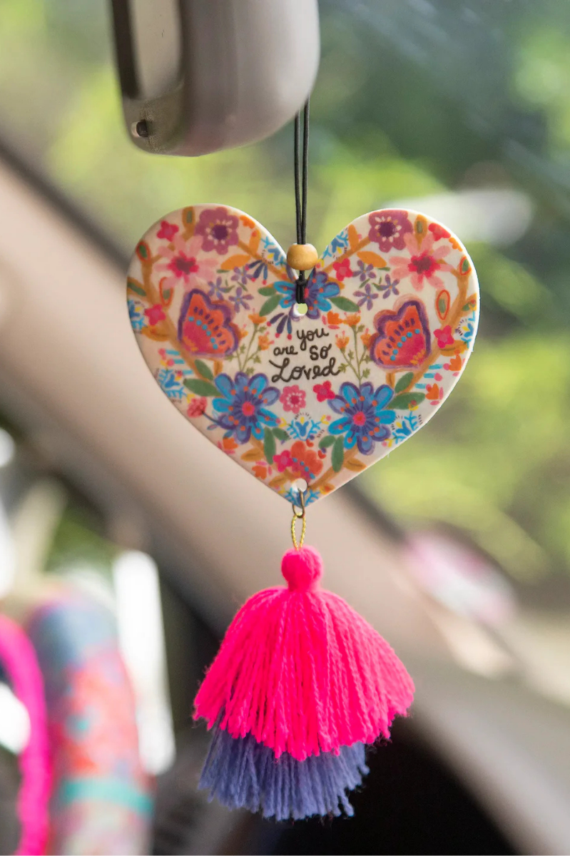 You Are So Loved Air Freshener | Natural Life | Spread the love with our You Are So Loved Air Freshener! Infused with Rose Musk-scented essential oil, this double-sided freshener not only adds a boho vibe with a yarn tassel and wooden bead, but it also brings a lovely scent to your car or personal space. Elastic string makes it easy to hang anywhere.
Scent: Rose Musk-scented essential oil
Pressed paper with essential oils and natural and artificial preservatives, exclusive of trim. Phthalate free