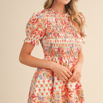 Woman wearing a floral dress against a beige background