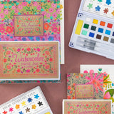 Colorful watercolor paint sets with floral designs on a brown background