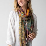 Woman wearing a colorful floral scarf on a plain background