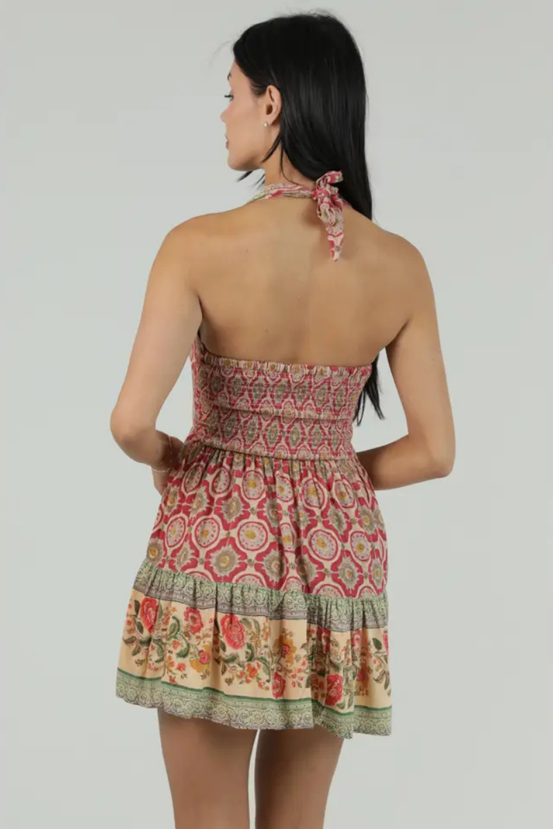 Woman wearing a patterned dress with a plain background