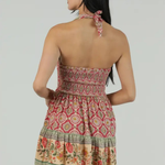 Woman wearing a patterned dress with a plain background
