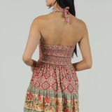 Woman wearing a patterned dress with a plain background