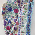 Floral-patterned headband with a button on a white background