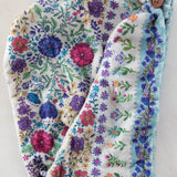 Floral-patterned headband with a button on a white background