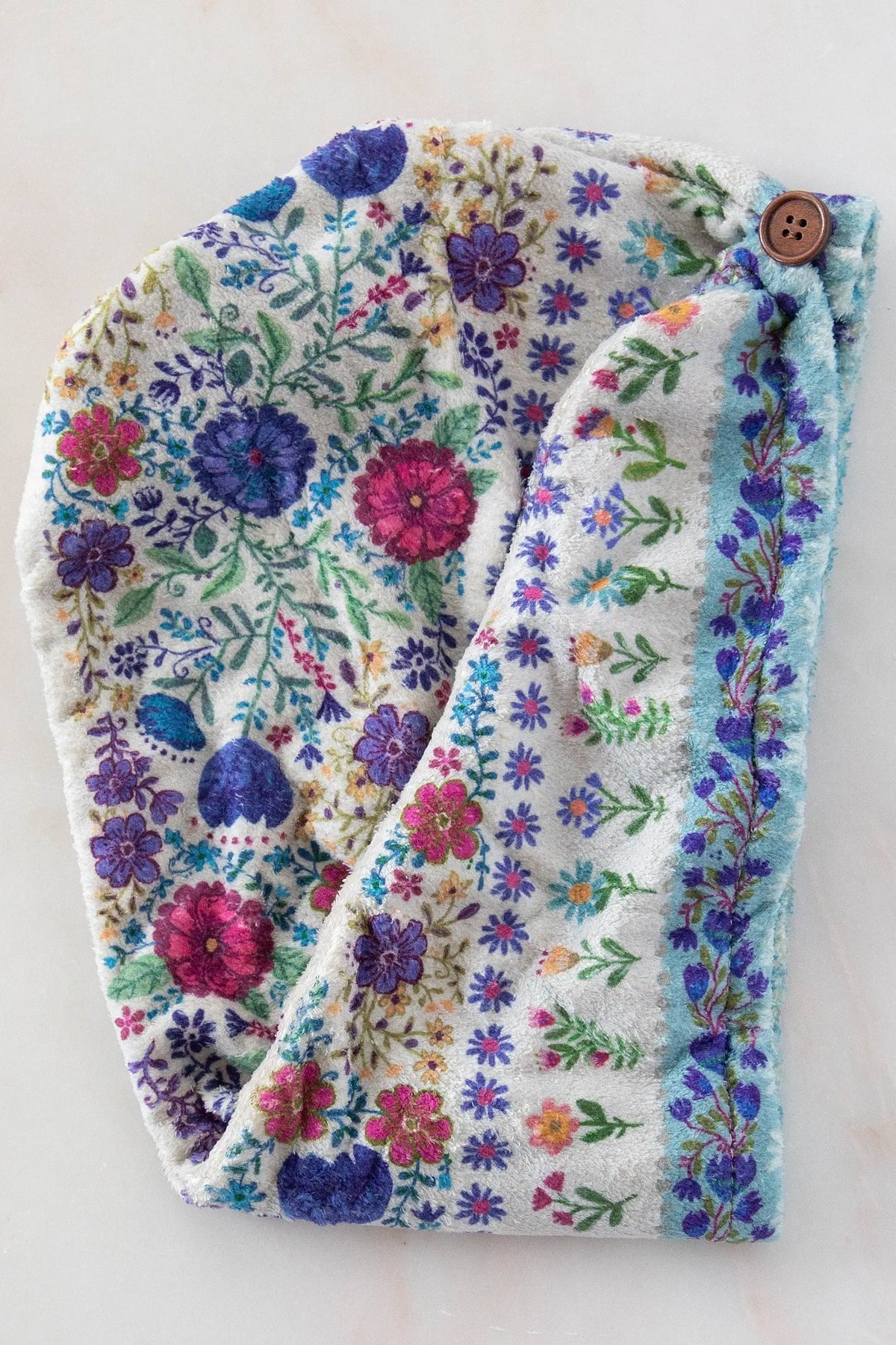 Floral-patterned headband with a button on a white background