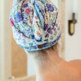 Person with a floral towel wrapped around their head in a bathroom setting