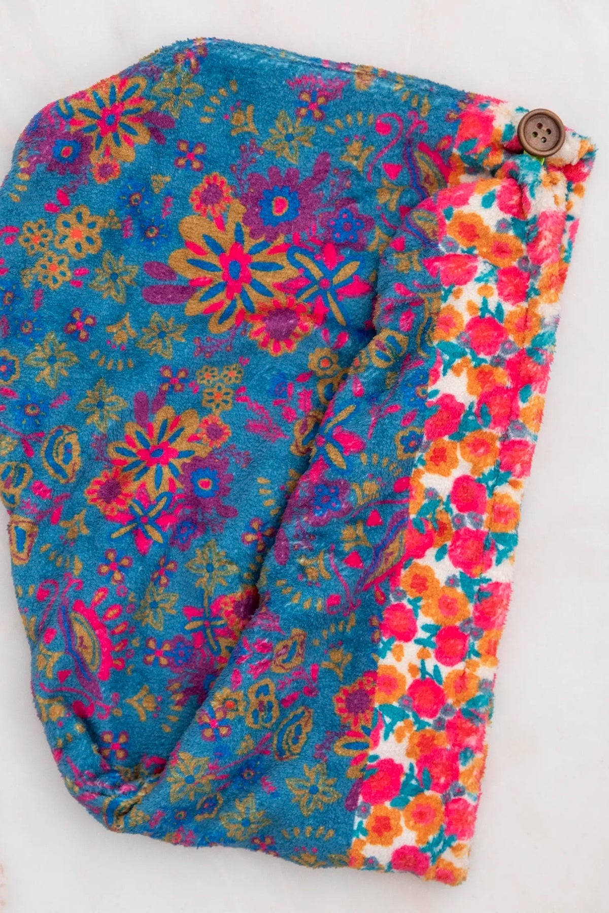 Colorful floral-patterned fabric with a button on a white background