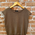 Brown sleeveless sweater vest on a wooden hanger against a brick wall.