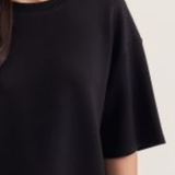 Black t-shirt worn by a person on a light gray background