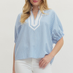 Woman wearing a blue and white striped blouse with a plain background