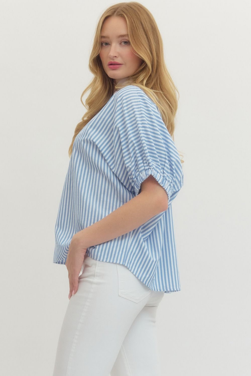 Woman wearing a blue and white striped shirt with a plain background