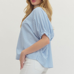 Woman wearing a blue and white striped shirt with a plain background