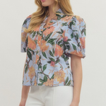 Woman wearing a floral blouse with a plain background