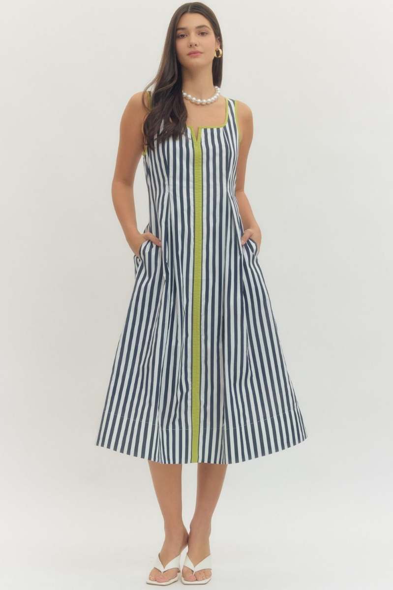 Woman wearing a black and white striped dress with a yellow zipper on a white background