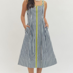 Woman wearing a black and white striped dress with a yellow zipper on a white background