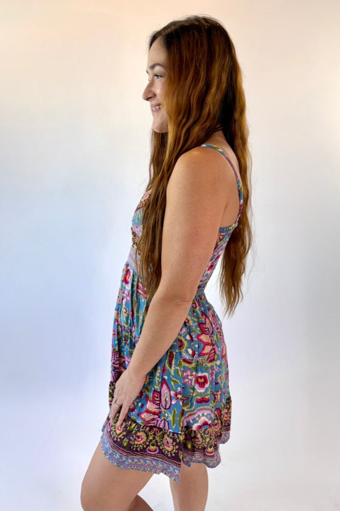 Woman wearing a colorful floral dress against a white background
