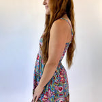 Woman wearing a colorful floral dress against a white background
