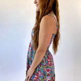Woman wearing a colorful floral dress against a white background