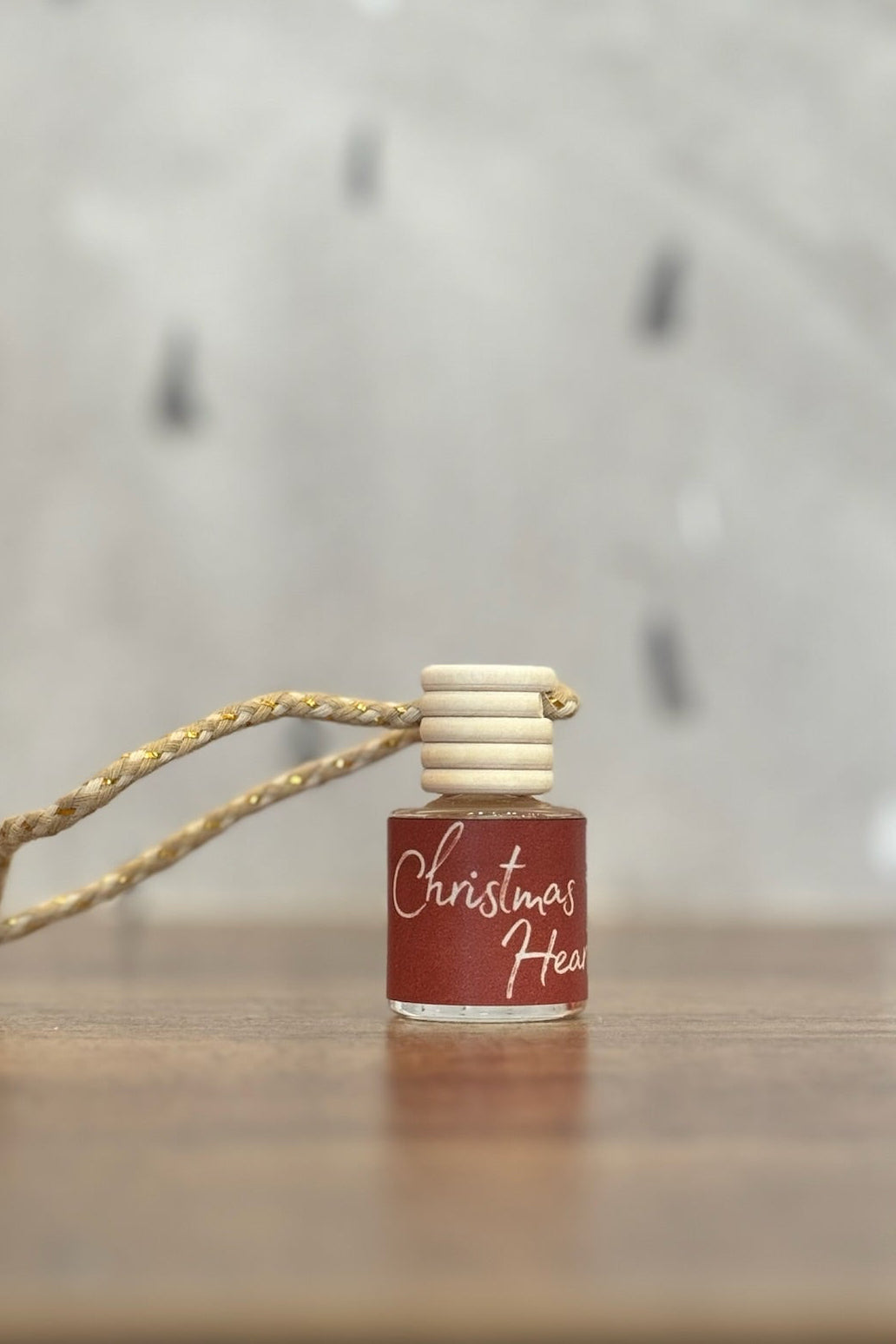 Small bottle with a wooden cap and string on a wooden surface with a blurred background