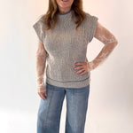 Woman wearing a striped sleeveless top and jeans on a white background