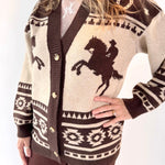 Person wearing a patterned cardigan with a horse design on a white background