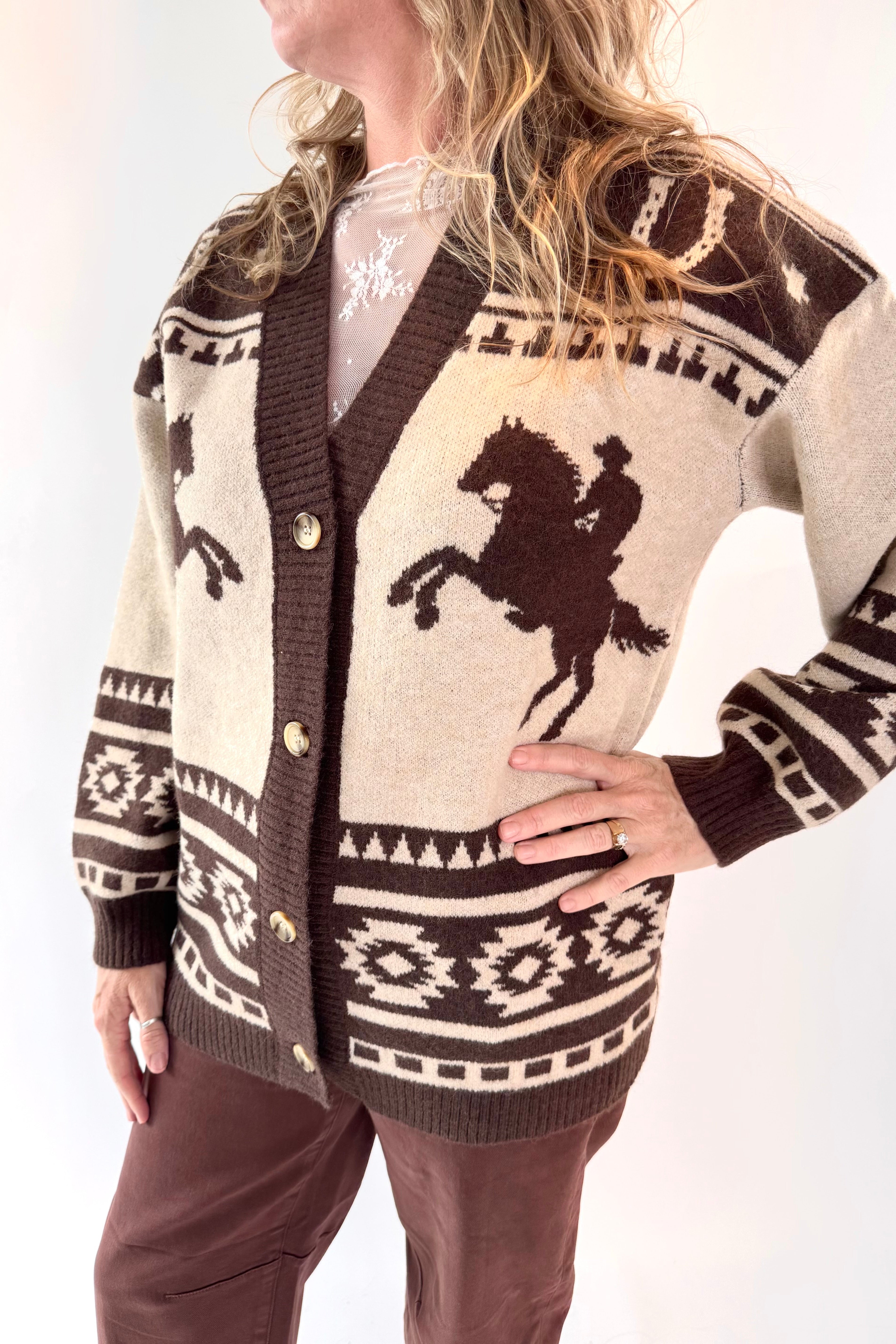 Person wearing a patterned cardigan with a horse design on a white background