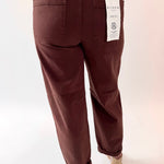 Brown pants with a visible brand label on a white background