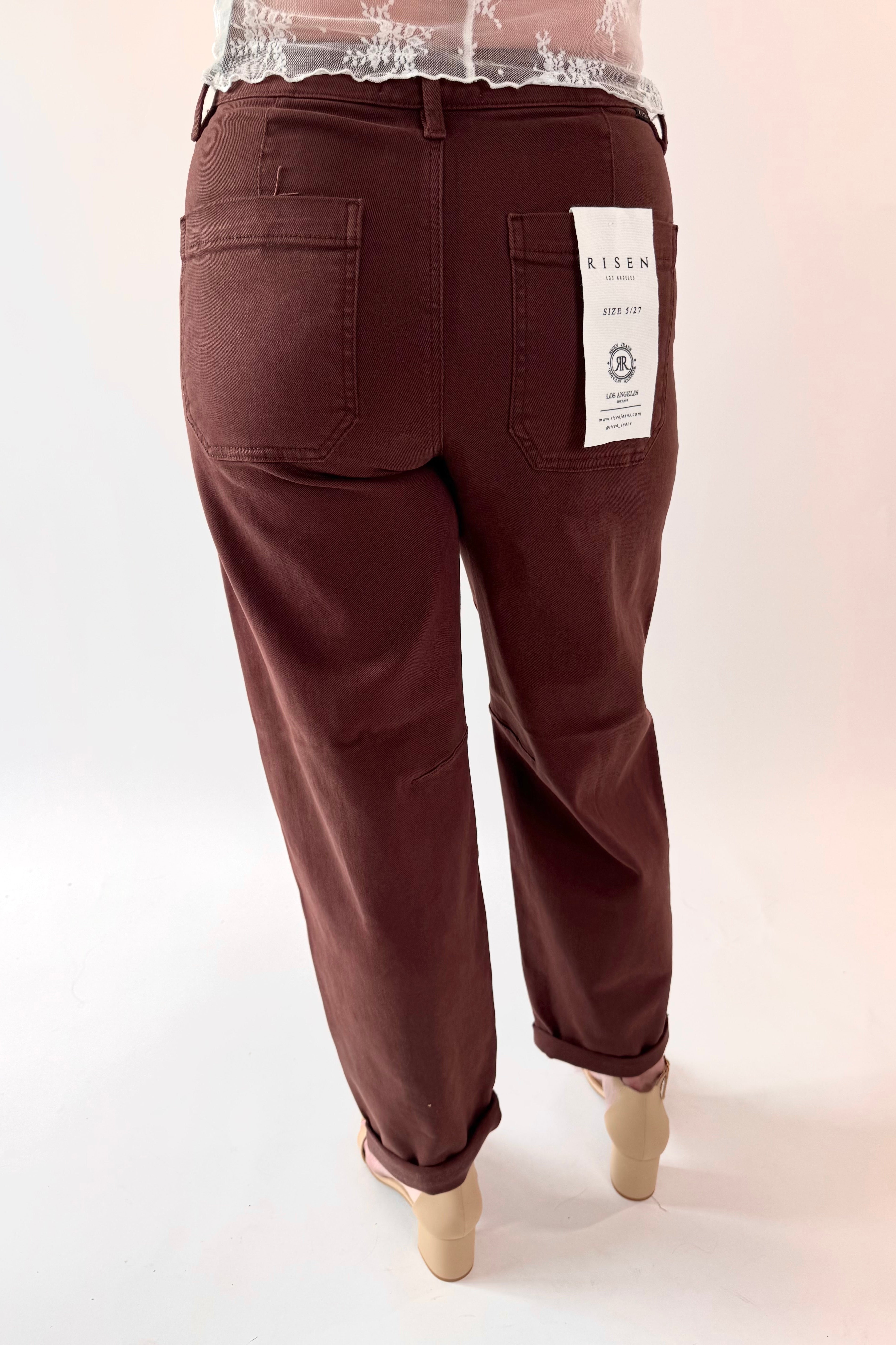 Brown pants with a visible brand label on a white background