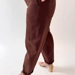 Brown pants worn by a person on a white background