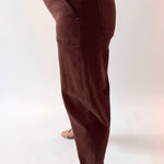Brown pants worn by a person on a white background