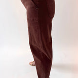 Brown pants worn by a person on a white background