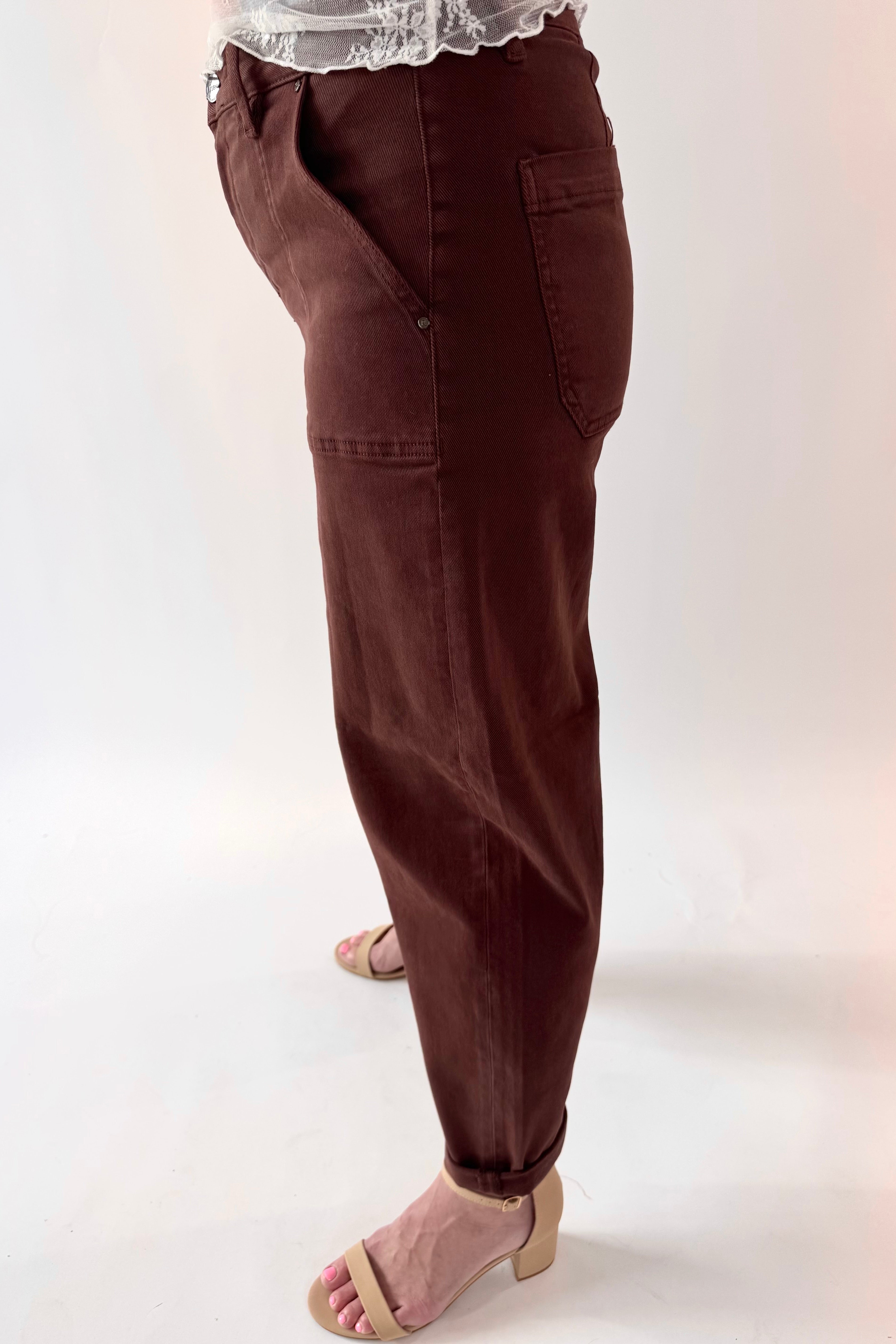 Brown pants worn by a person on a white background