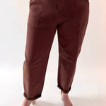 Brown pants worn by a person on a white background