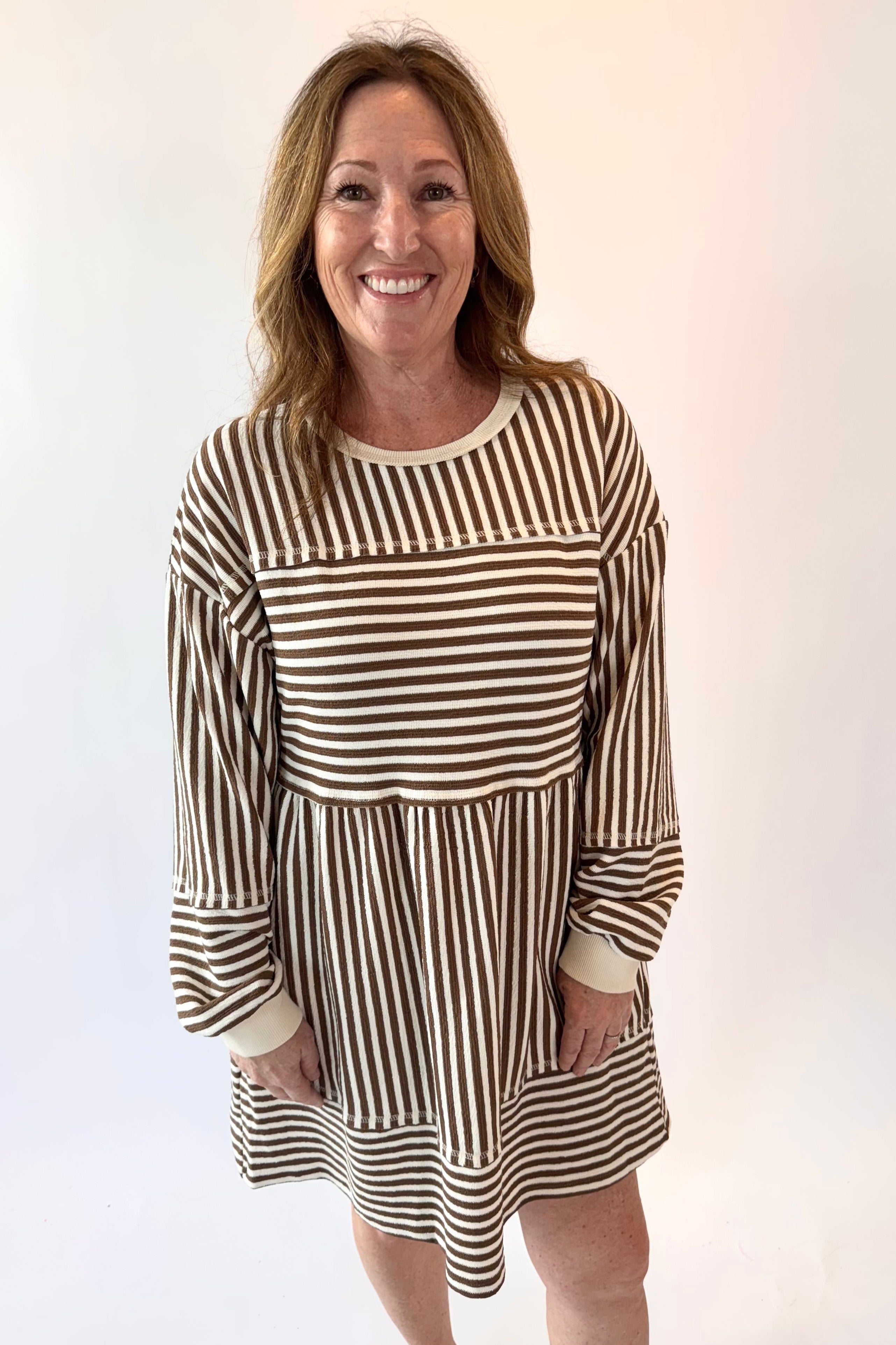 Woman wearing a striped dress against a white background