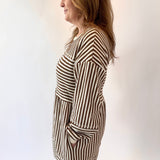 Woman wearing a black and white striped dress against a plain background