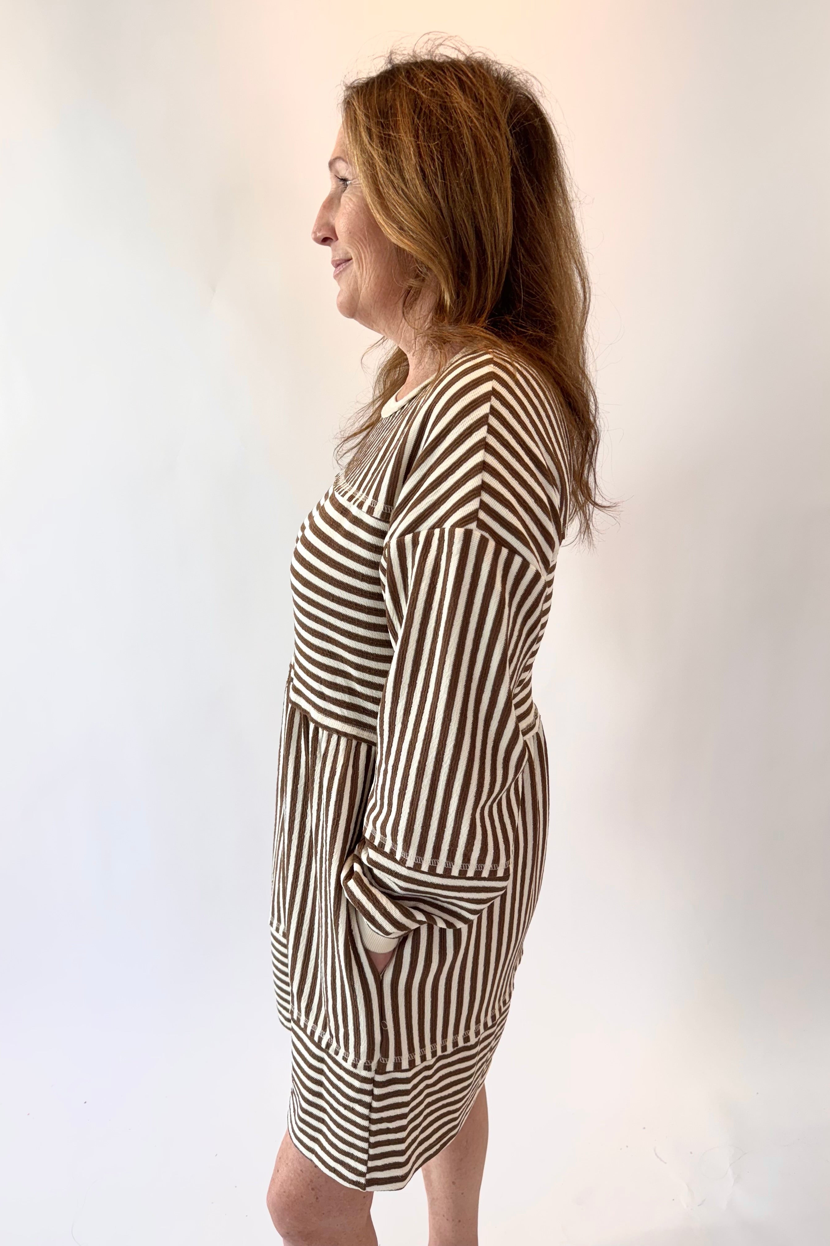 Woman wearing a black and white striped dress against a plain background