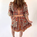 Person wearing a patterned dress with a backless design on a white background