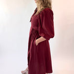 Woman wearing a burgundy dress against a white background
