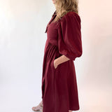 Woman wearing a burgundy dress against a white background