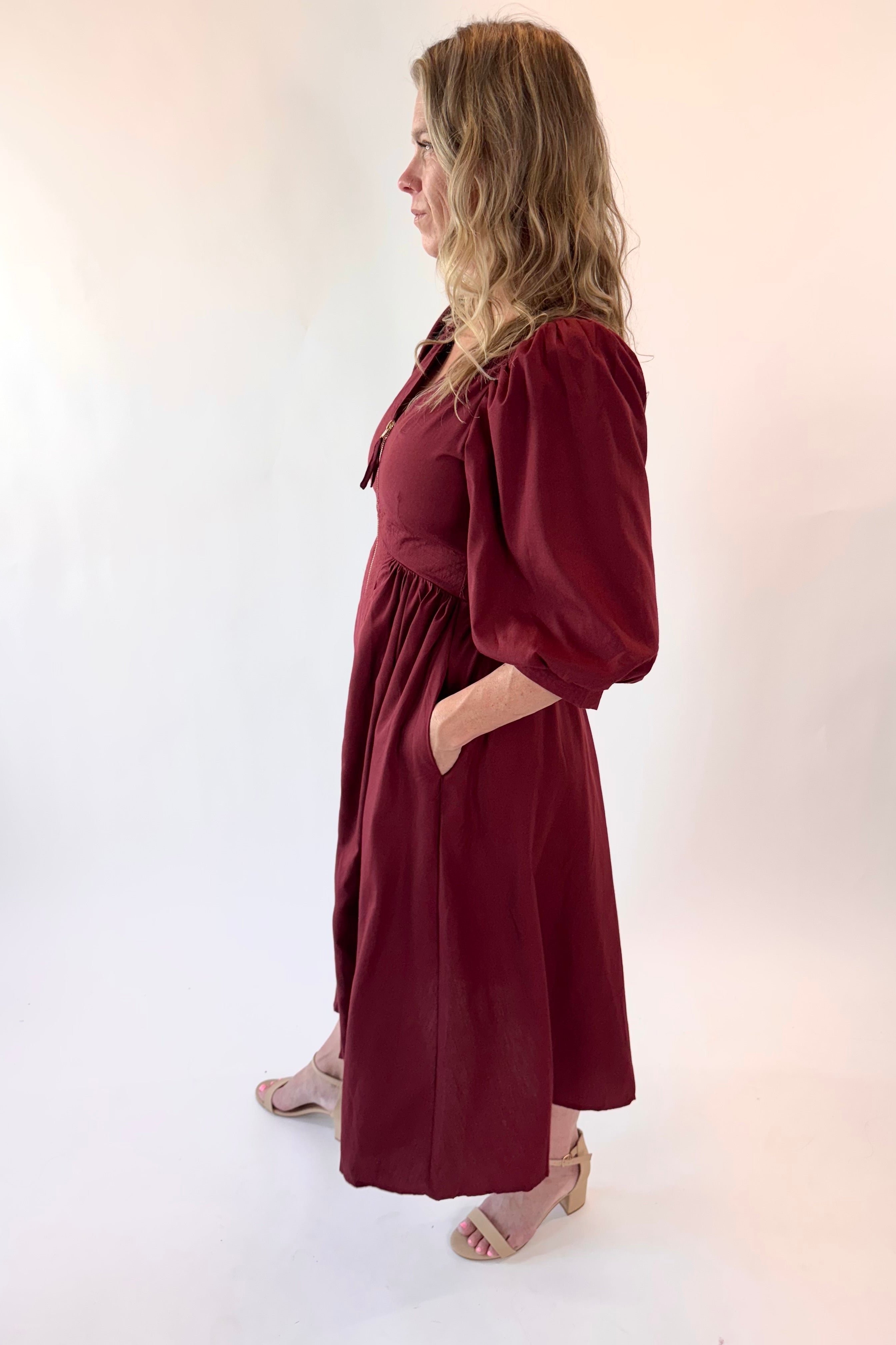 Woman wearing a burgundy dress against a white background