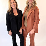 Two women standing side by side against a plain background