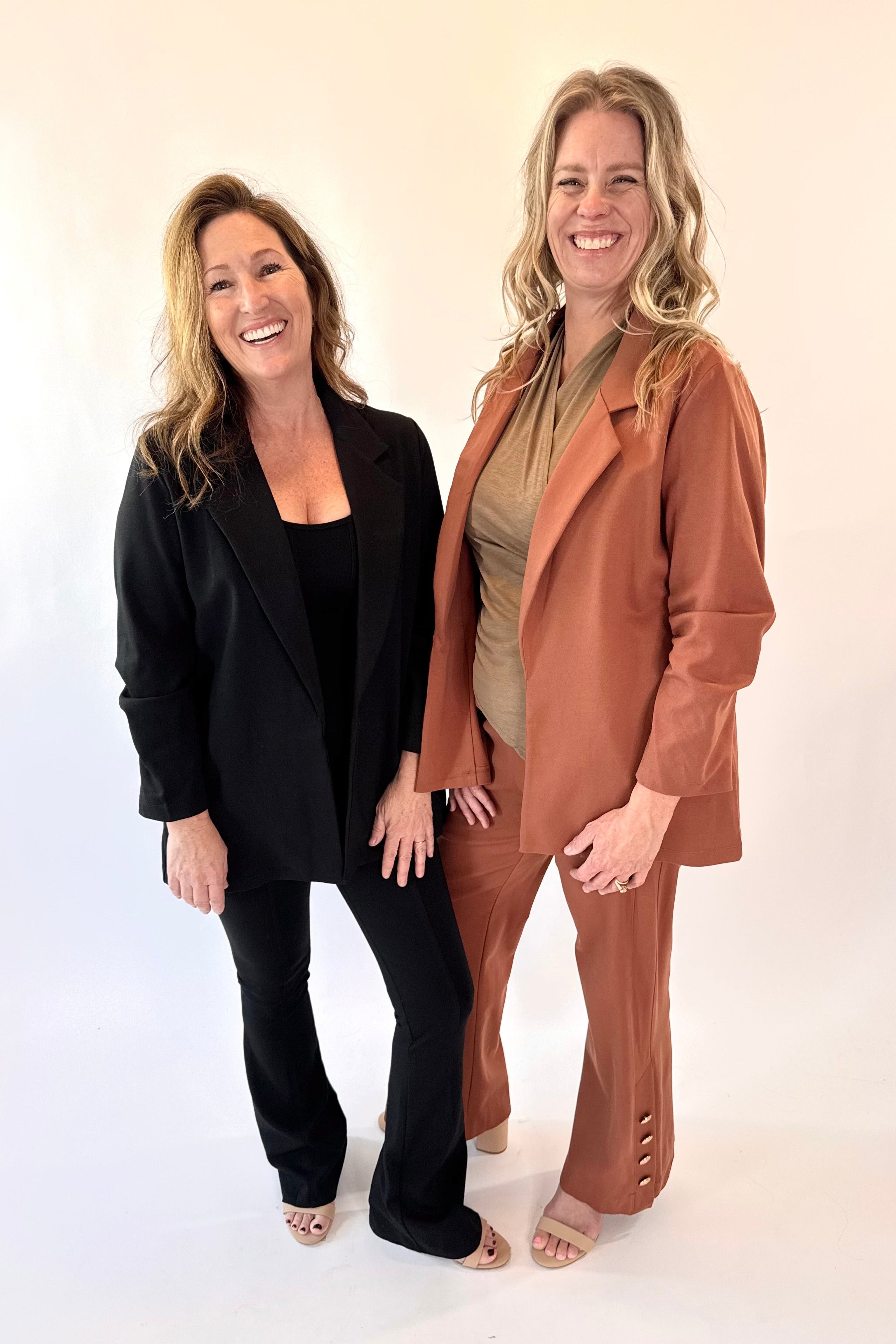 Two women standing side by side against a plain background
