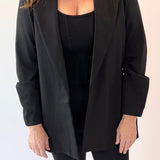 Woman wearing a black blazer and pants on a white background