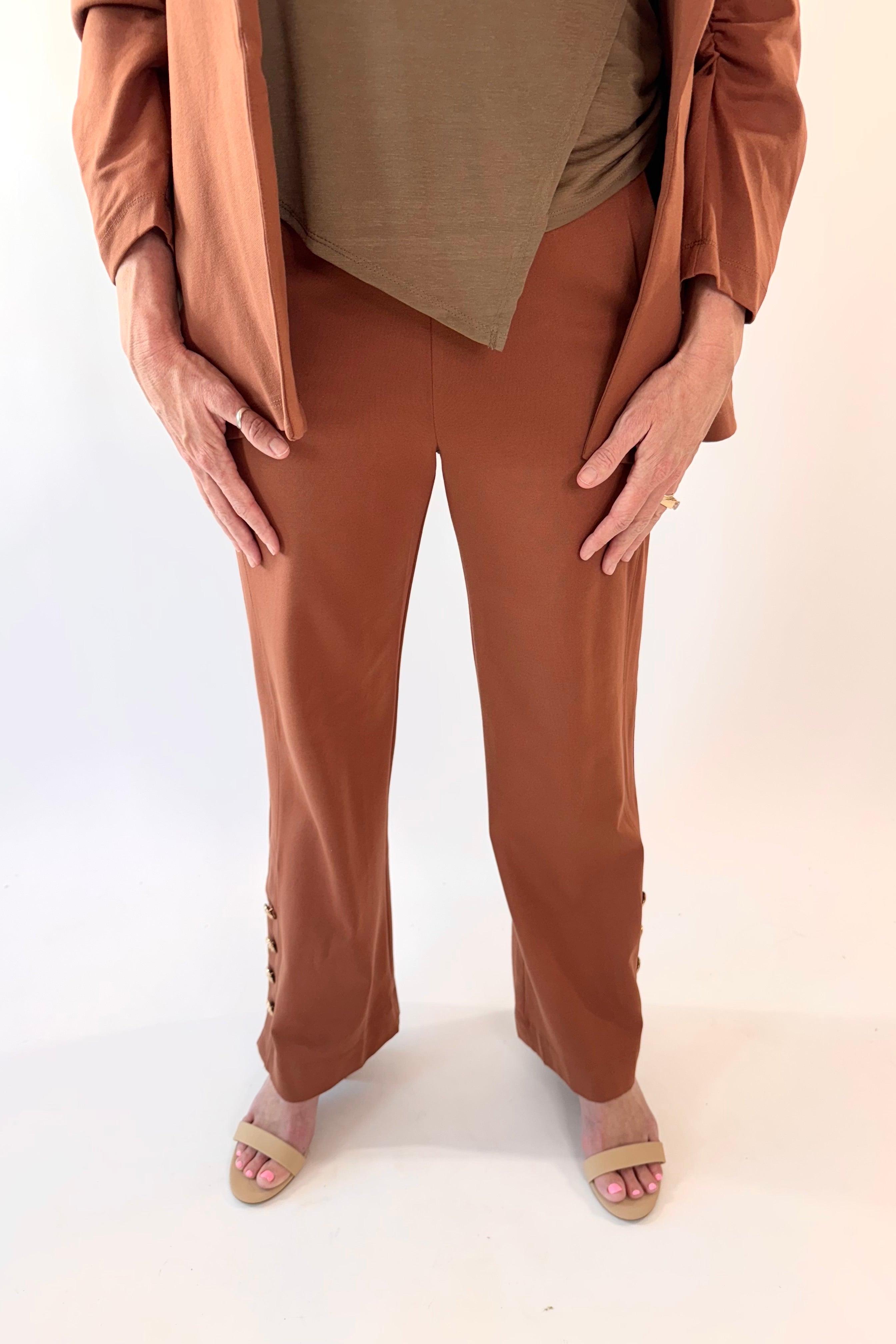 Person wearing a brown outfit with a beige top and pants on a white background